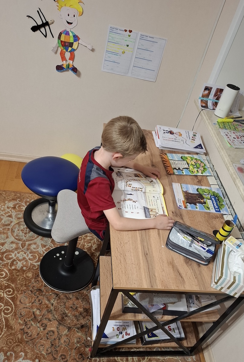 Kind am Schreibtisch mit Unterrichtsmaterial der Deutsche Fernschule